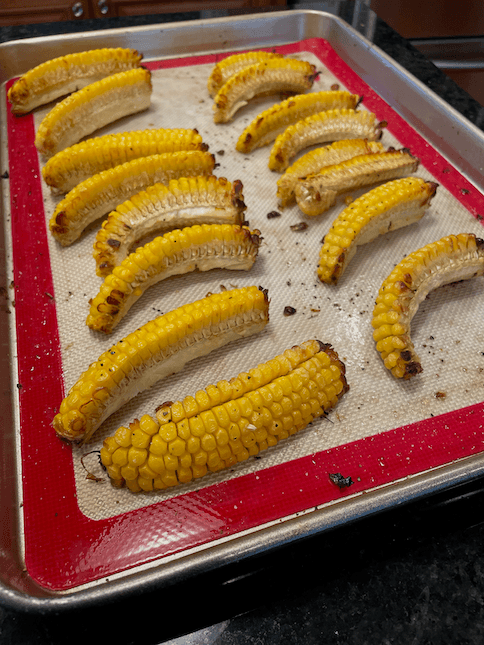 The corn is done when the kernels appear slightly wrinkly and the corncob has curved on the thinner pieces, but you can keep baking if you want more crispy bits.